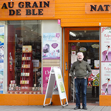 La devanture du magasin Au Grain de Blé de Saint-Étienne et son propriétaire, Roland Reymondier.